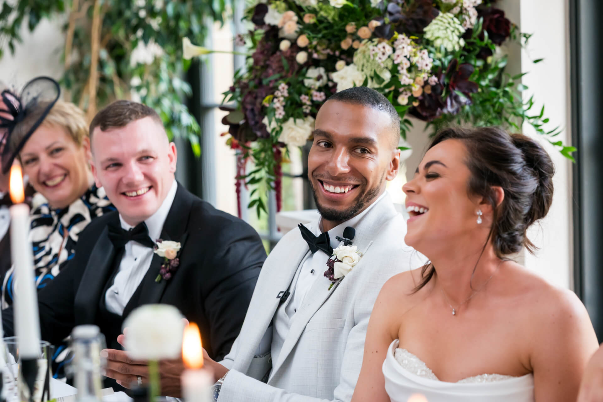 Smiling guests at a wedding reception table.