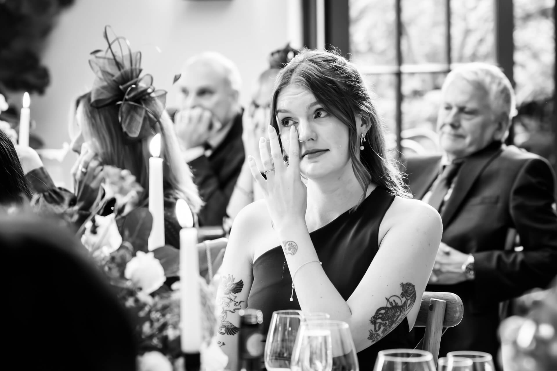 Woman emotional at wedding reception, black and white photo.