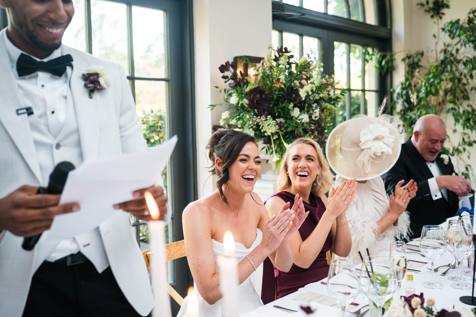 Wedding speech with guests clapping and smiling.