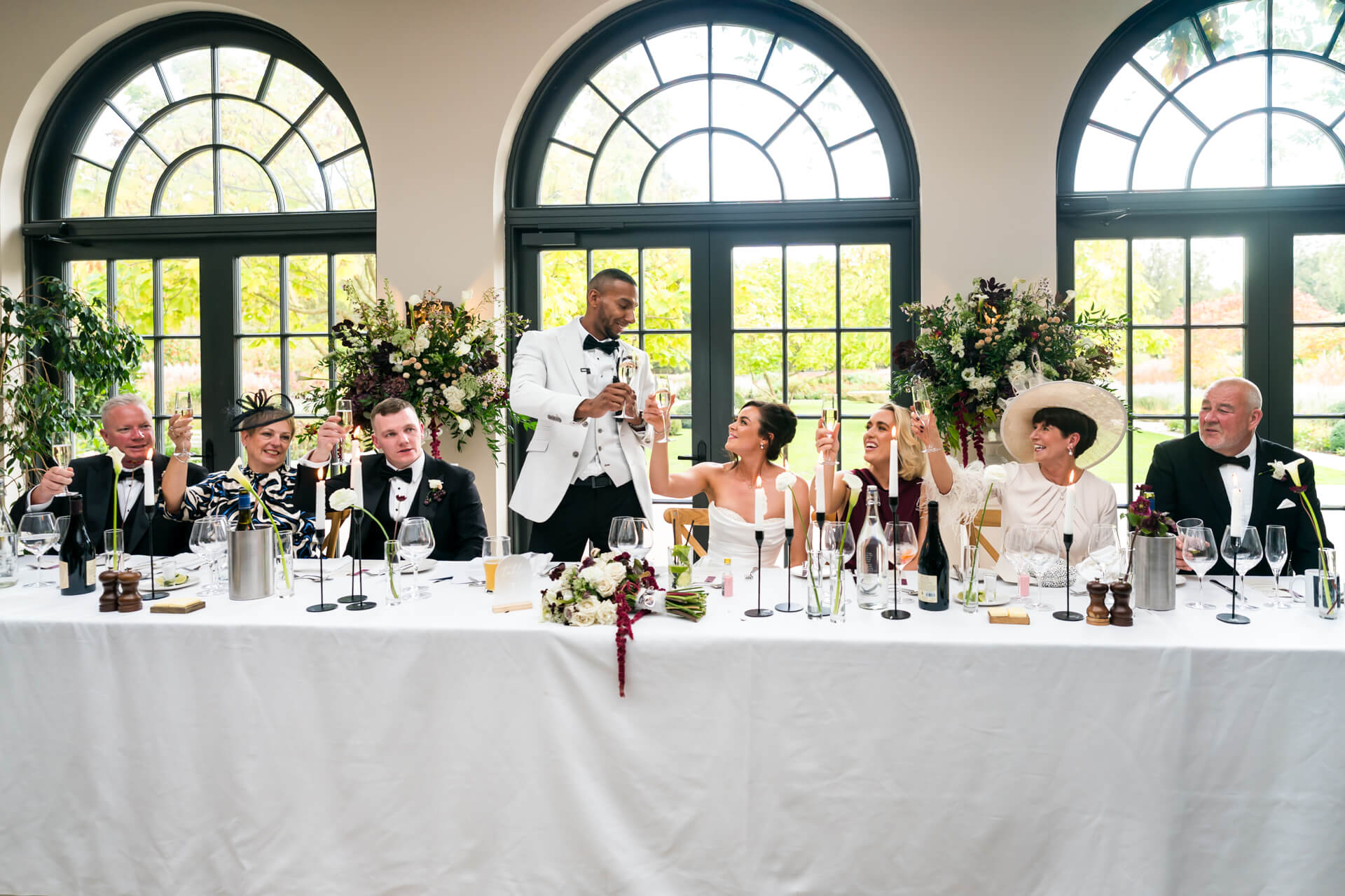 Wedding party toasting at a reception table.
