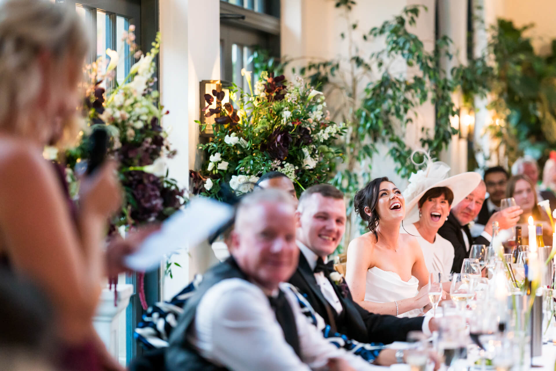 Wedding guests laughing during reception speech