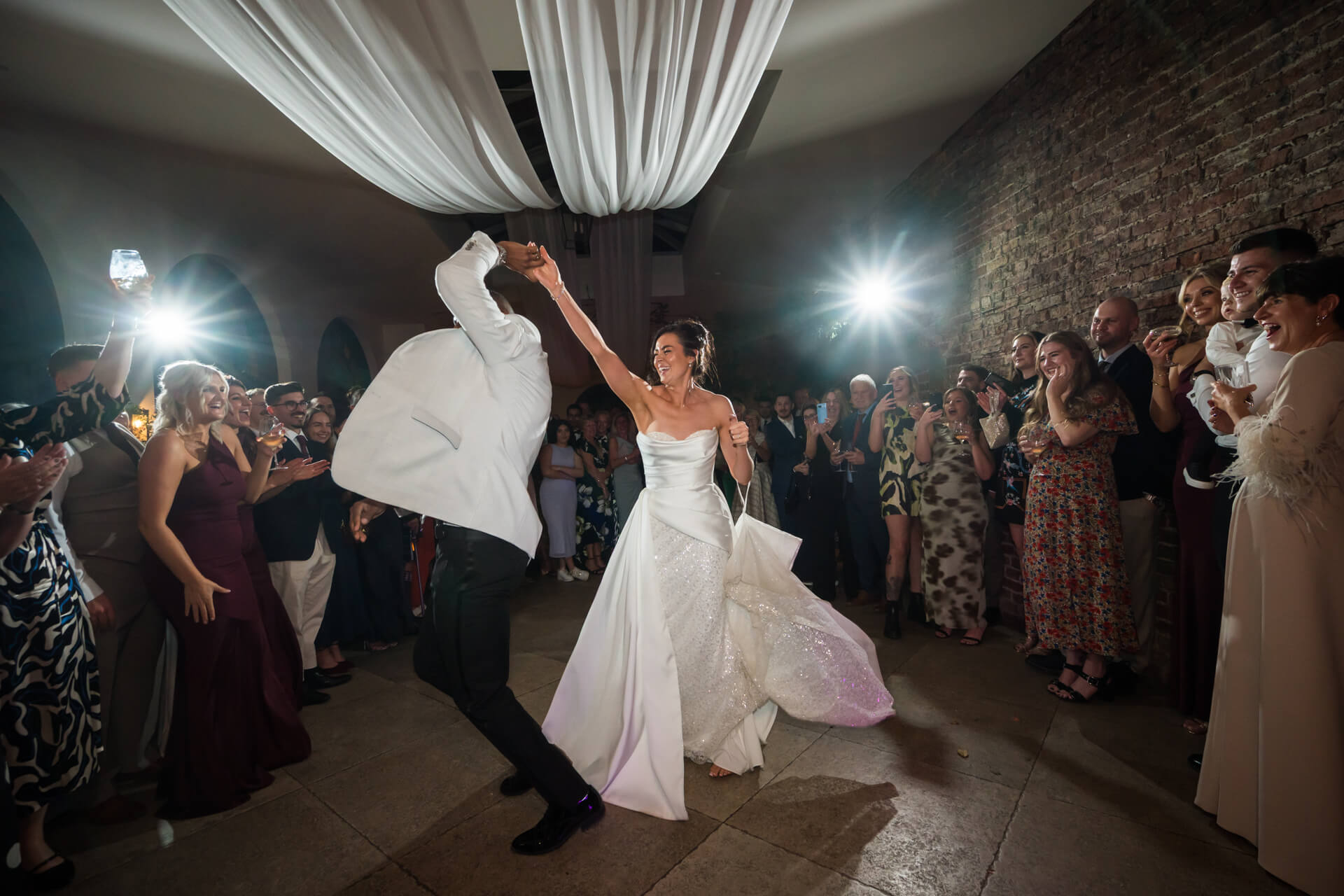 Bride and groom dancing at wedding reception celebration.