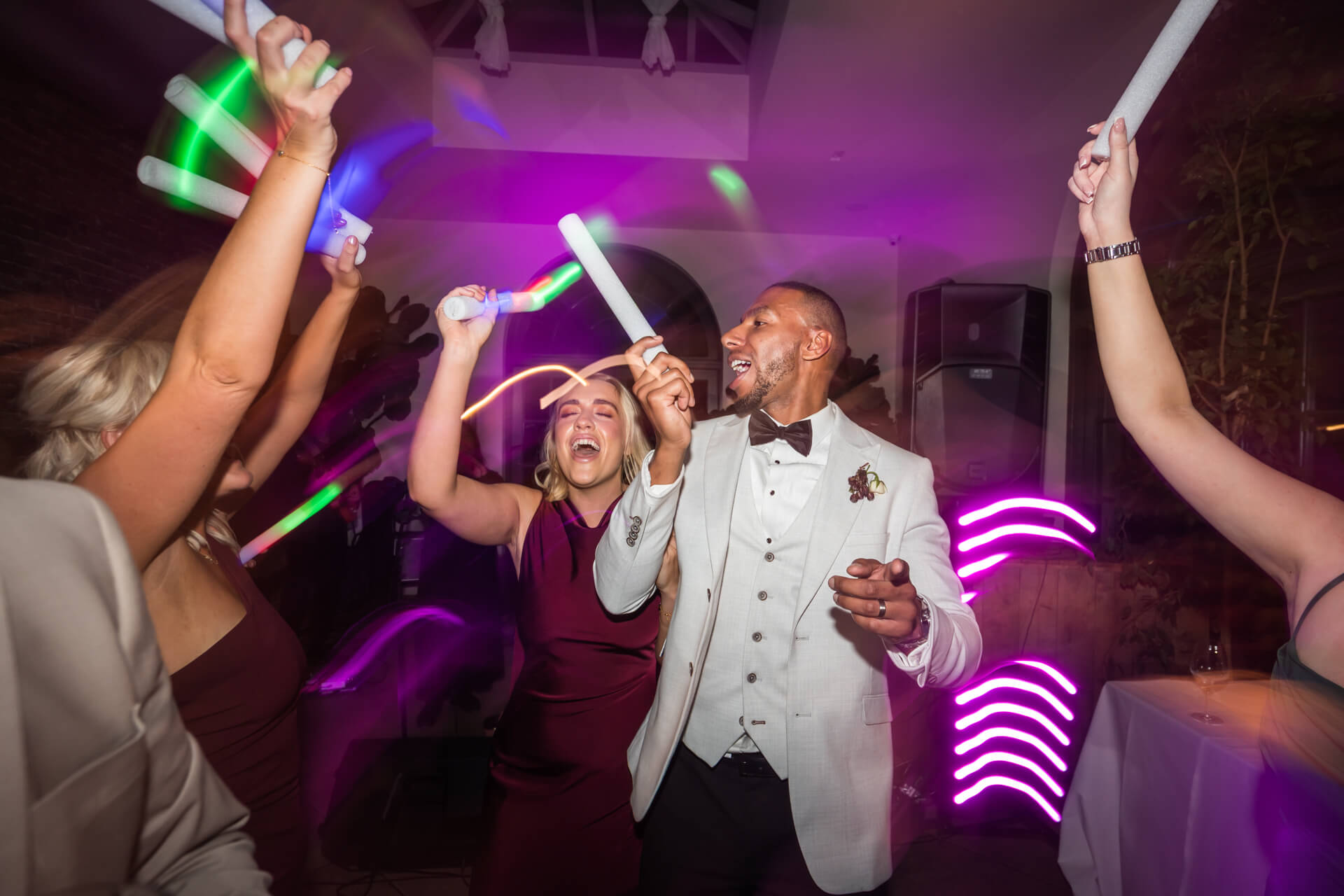 People dancing with glow sticks at party