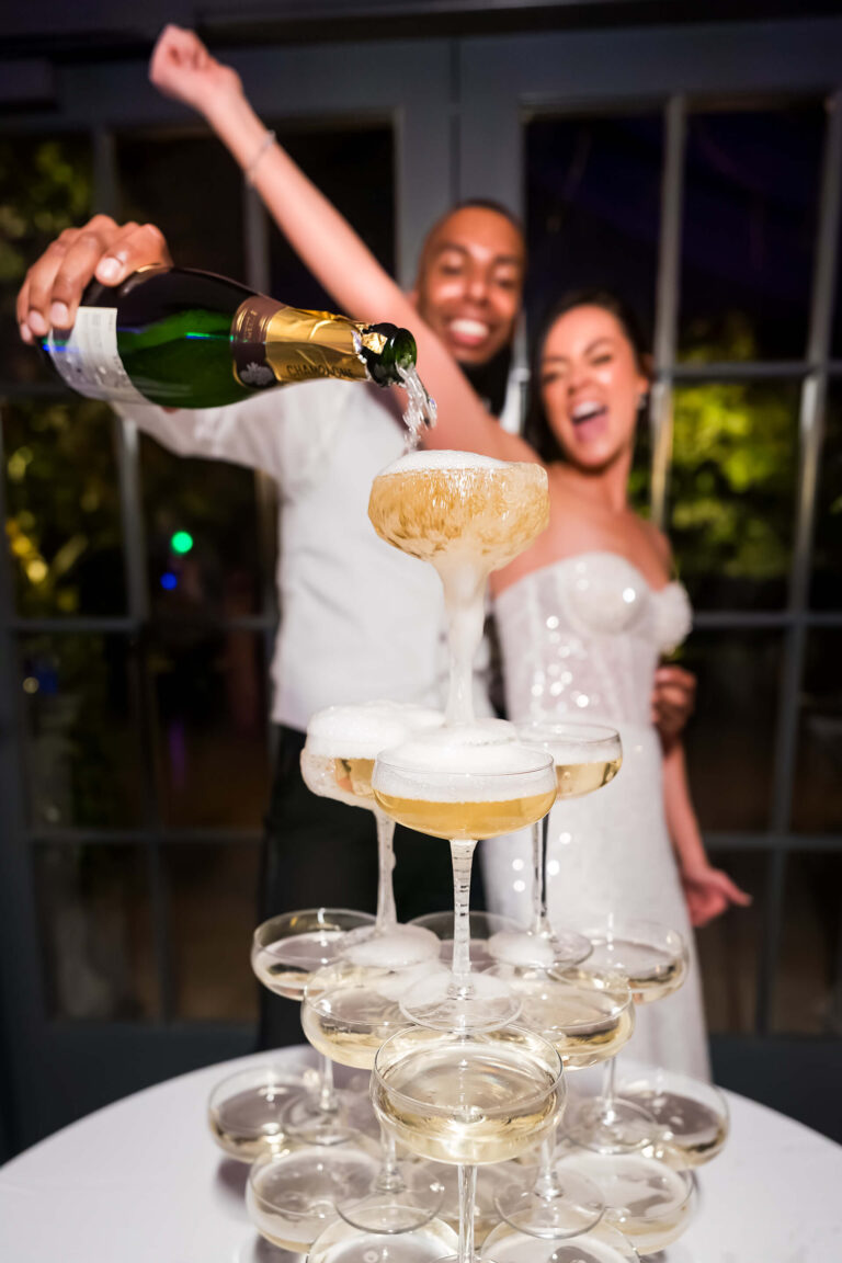 Couple pouring champagne on wedding day celebration.