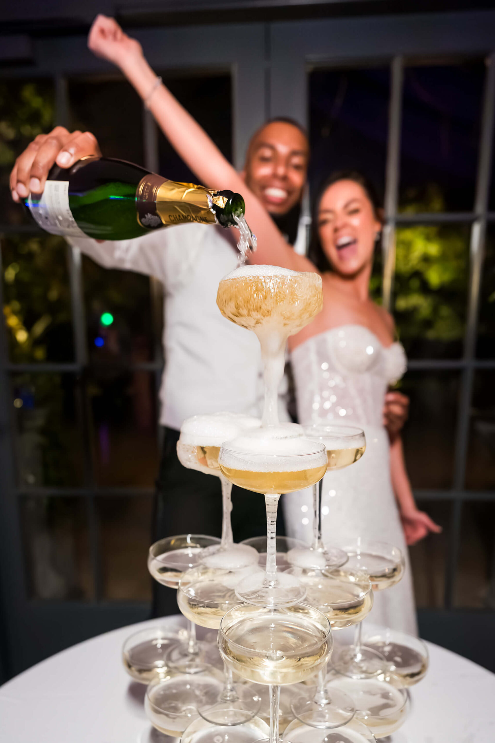 Couple pouring champagne on wedding day celebration.