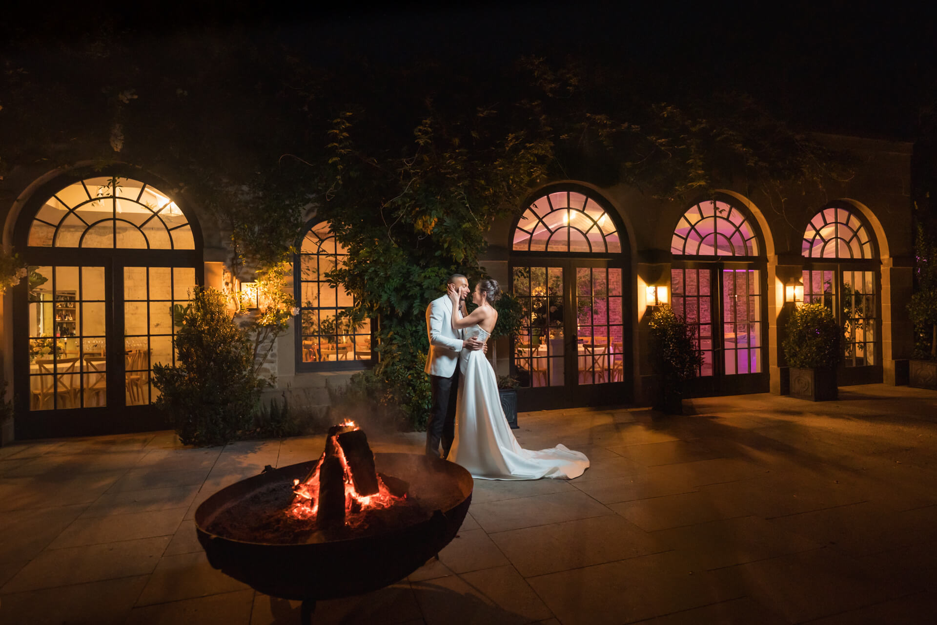 Couple dancing romantically by firepit at night
