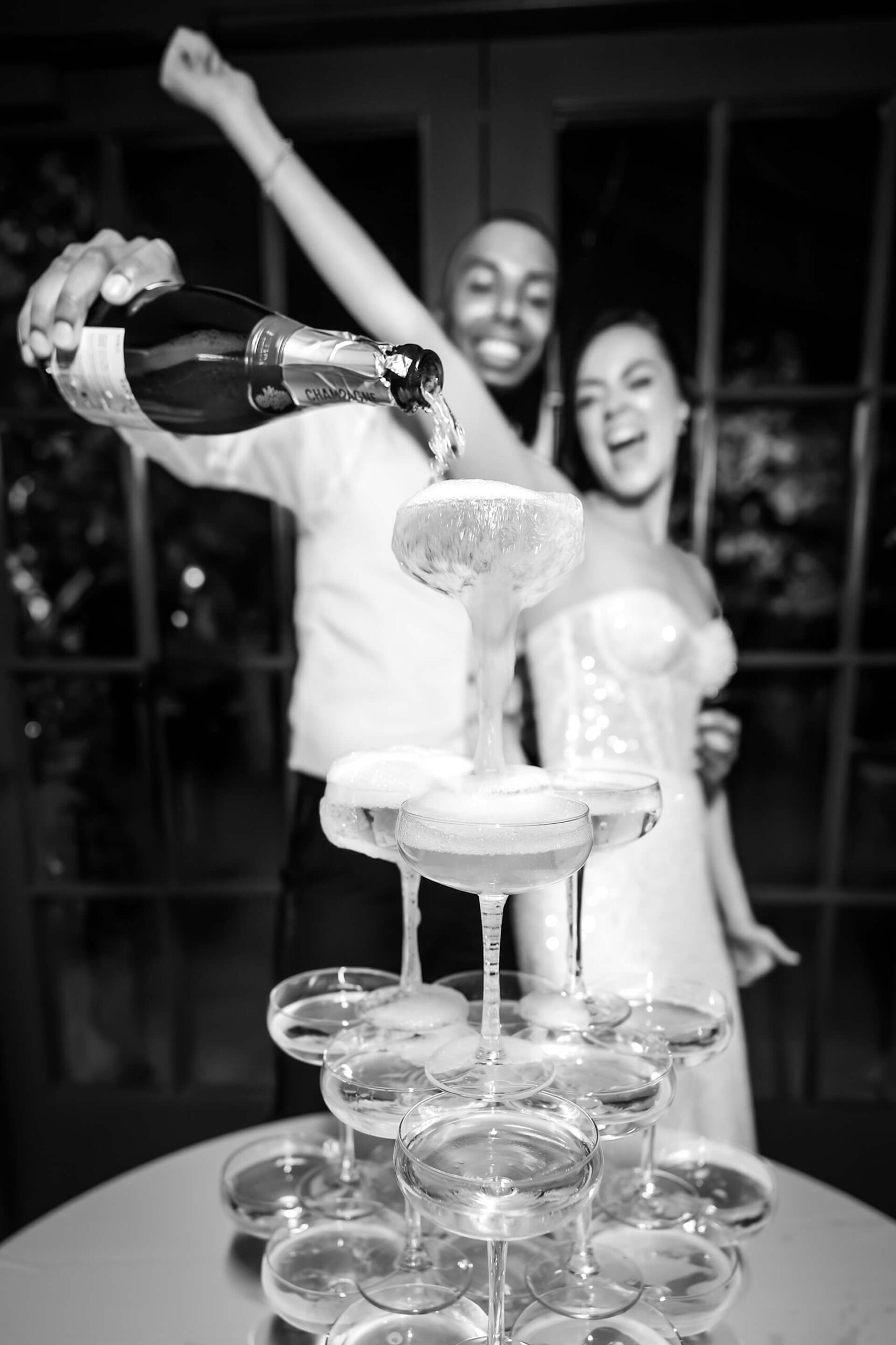 Champagne being poured into a tower of glasses.