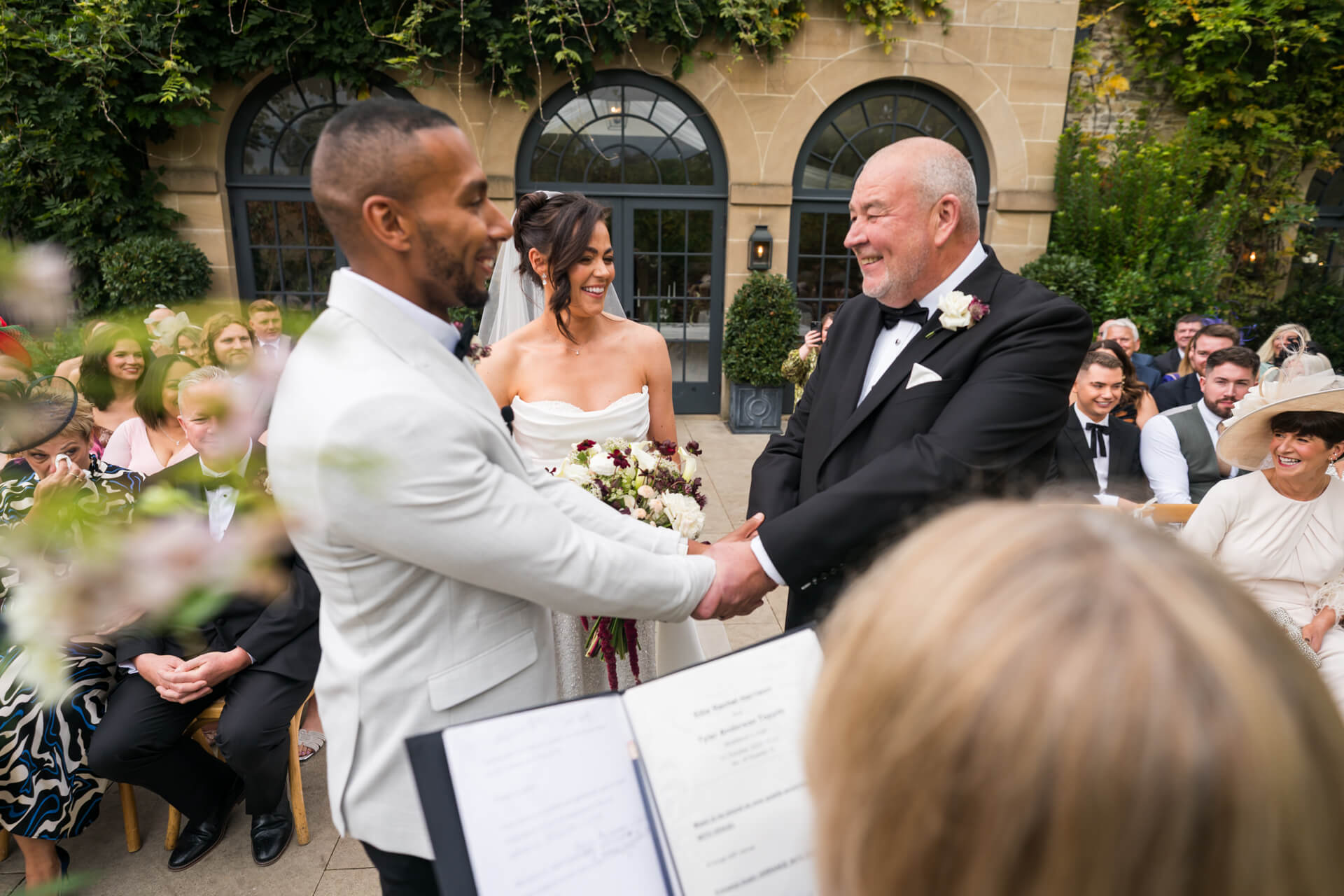 Wedding ceremony with couple and smiling guests.