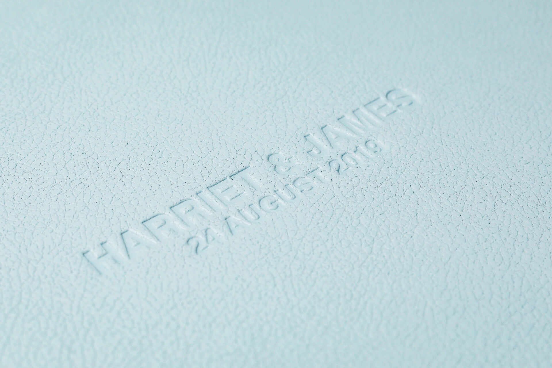 Embossed white leather with text and date.