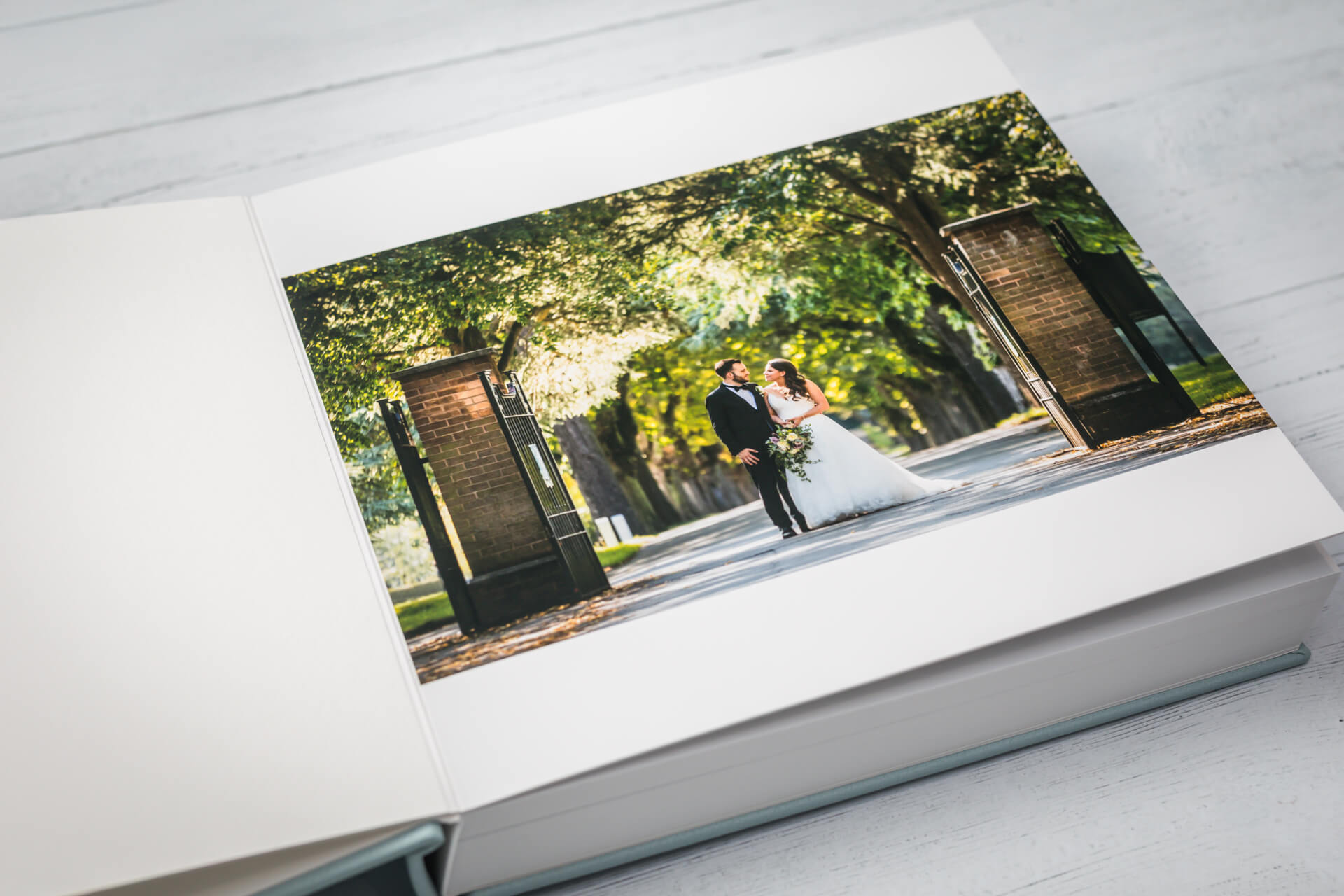 Open wedding album with couple photo outside.