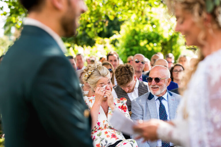 Guests emotional at outdoor wedding ceremony.