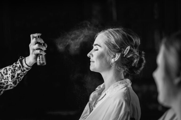 Woman having makeup applied with spray bottle