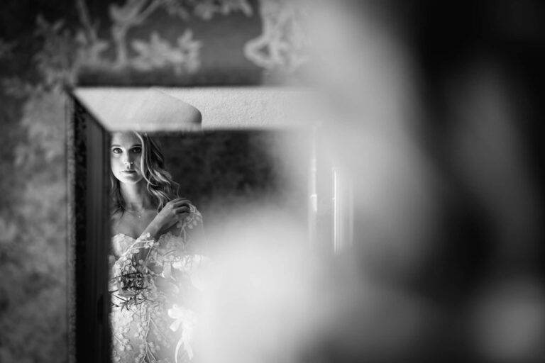 Bride reflected in mirror, romantic black and white portrait.