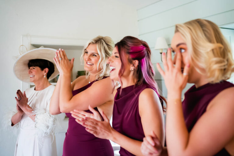 Women clapping and smiling at an event.