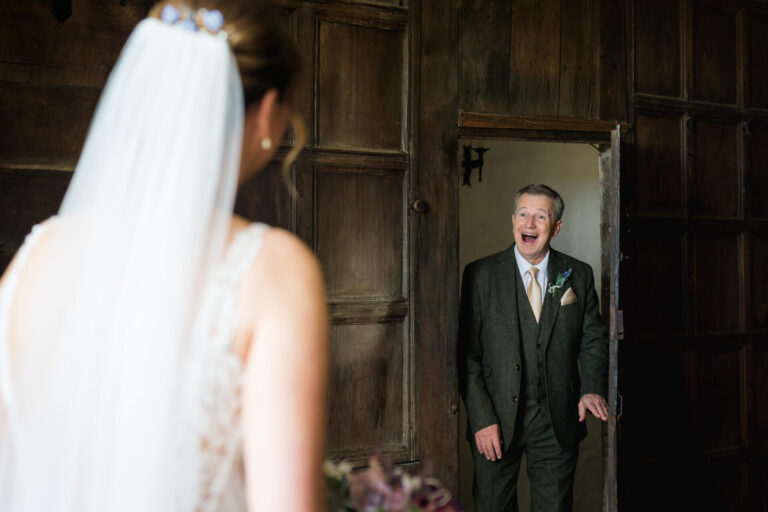 Man joyfully greets bride in doorway
