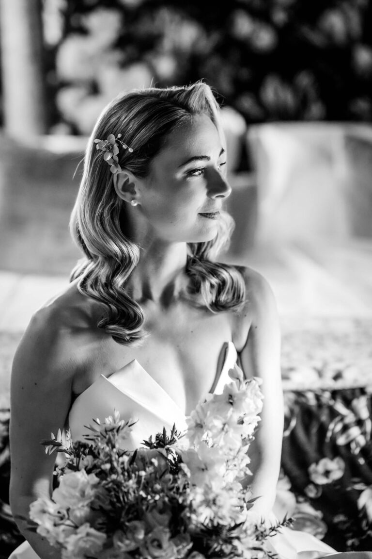 Bride with floral bouquet, elegant black and white portrait.