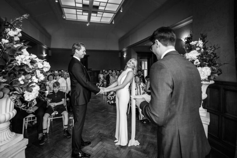 Wedding ceremony with couple holding hands.