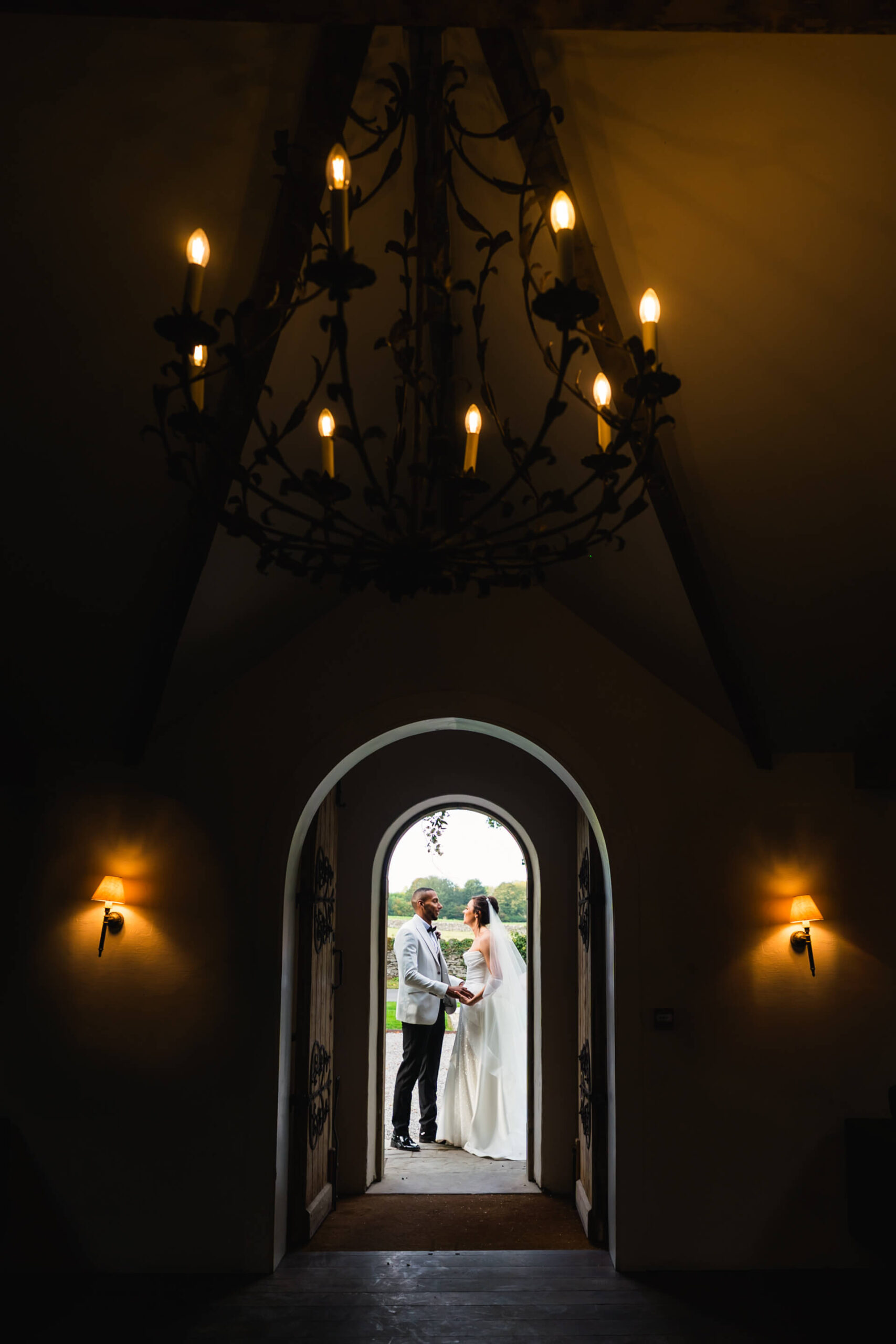 Bride and groom standing in arched doorway