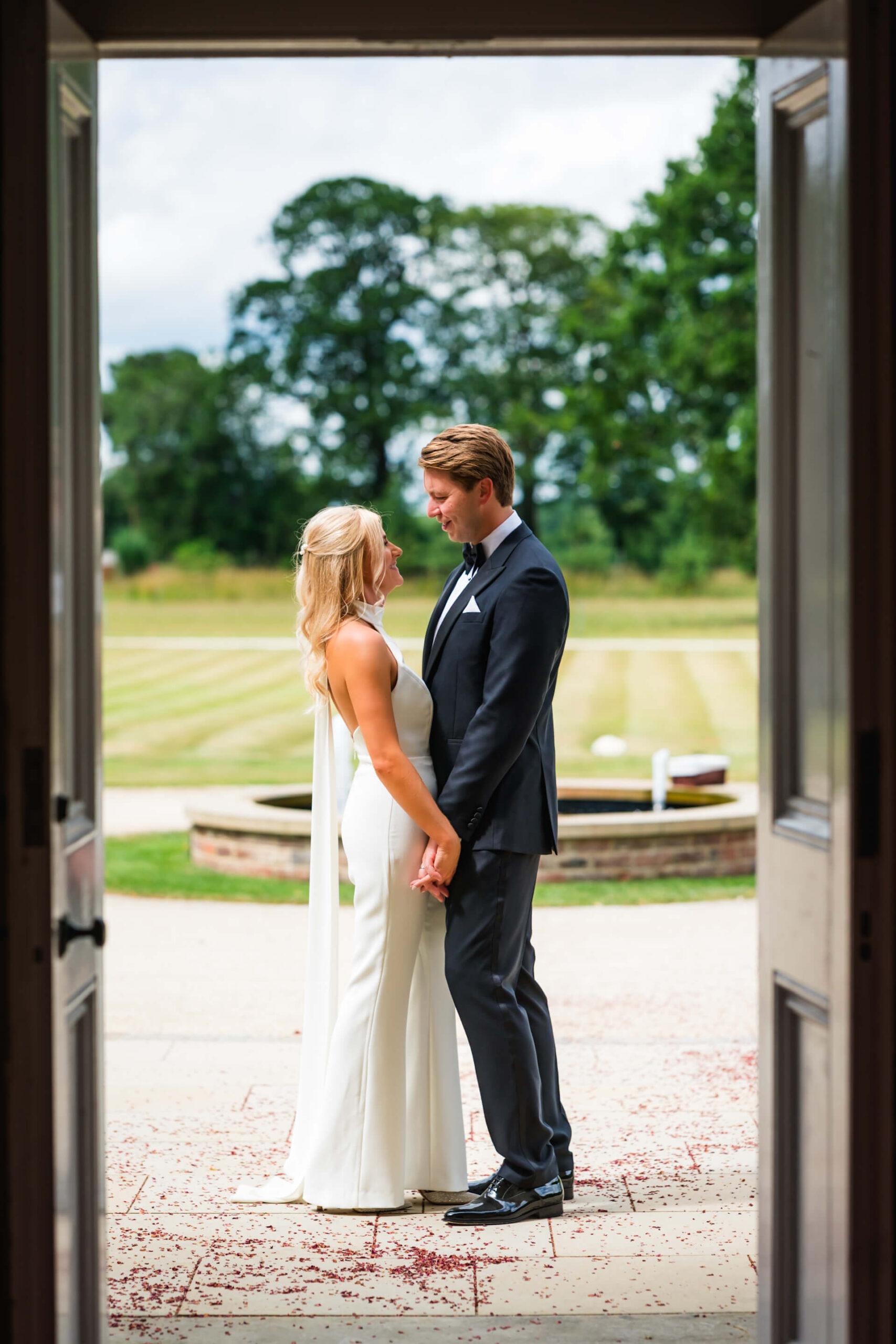 Couple holding hands, framed by a doorway.