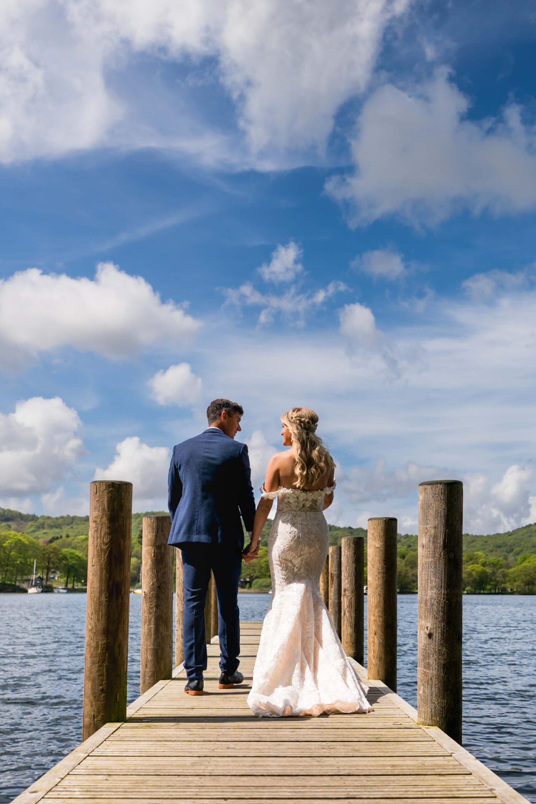 Bride and groom on a lakeside pier.