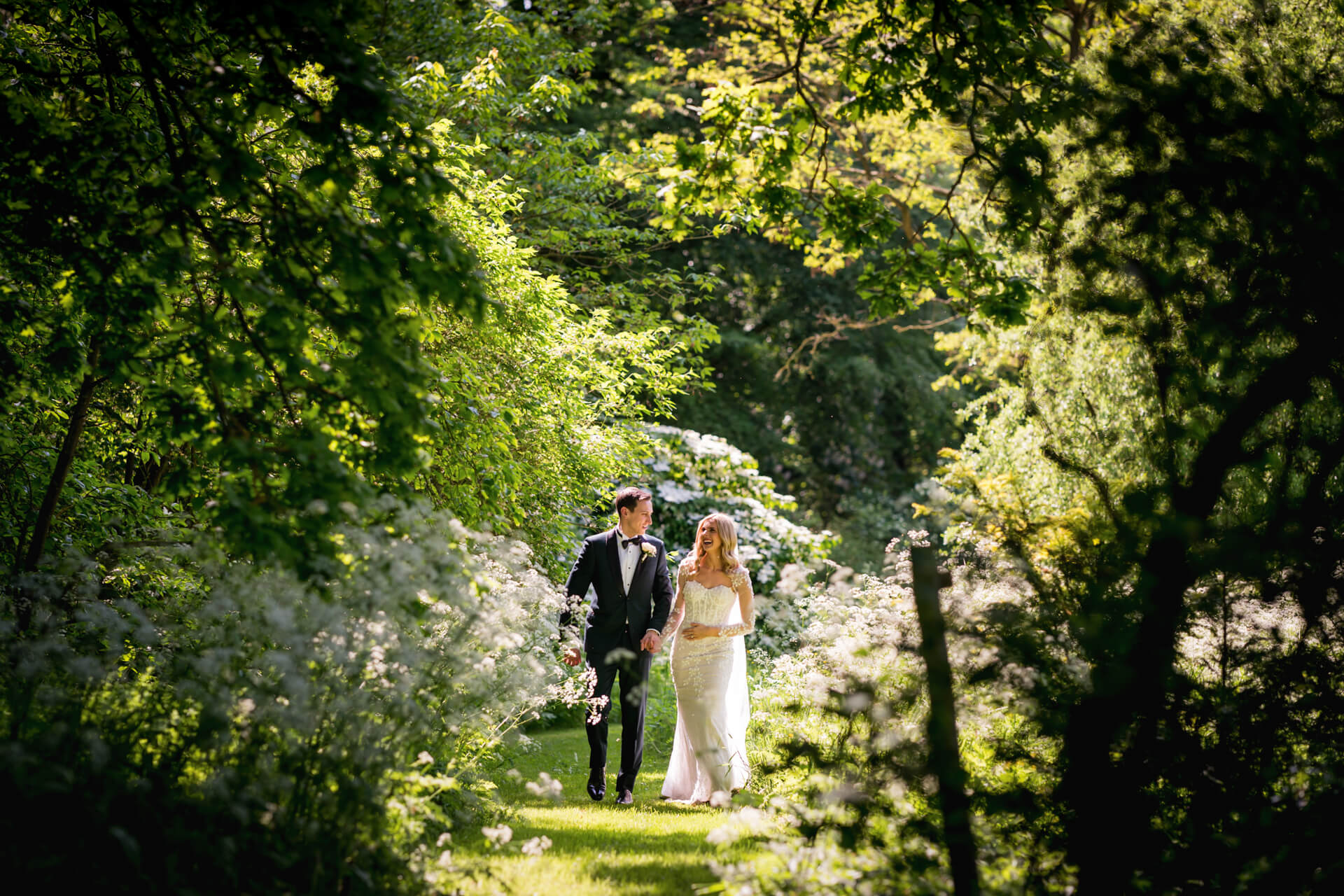 Bride and groom walking in a lush garden