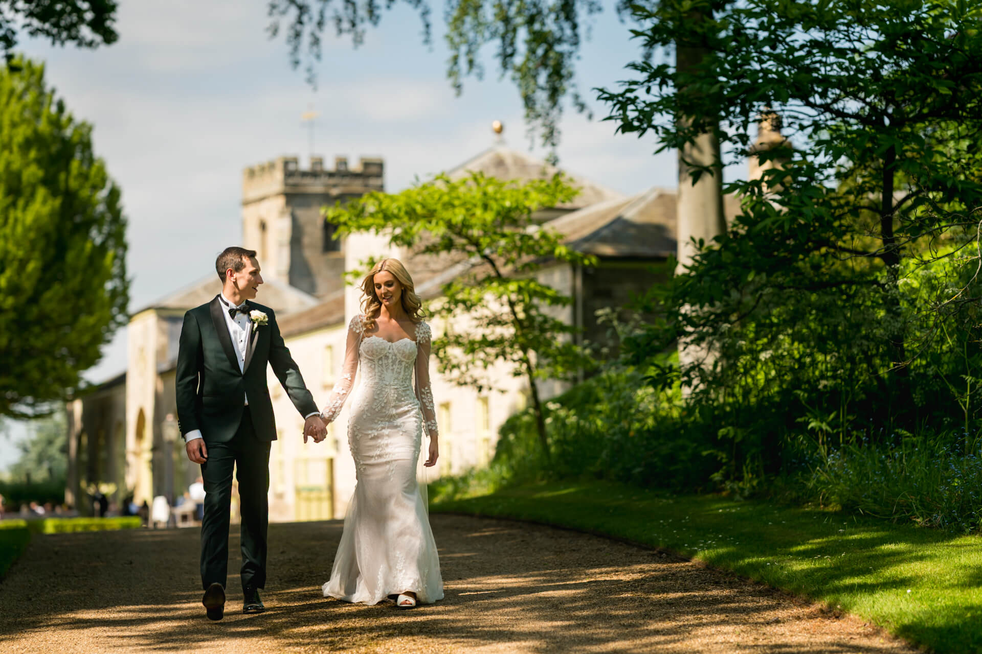 Wedding couple walking in garden lane.