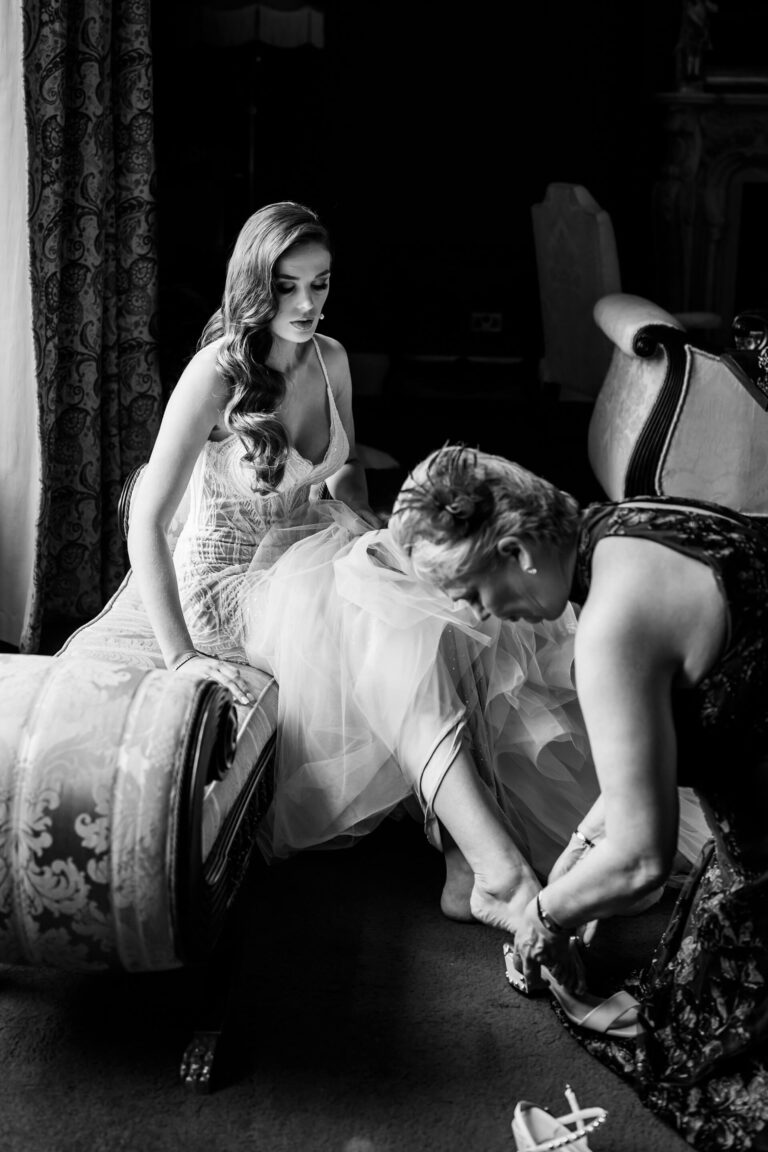 Bride preparing with help in elegant room.