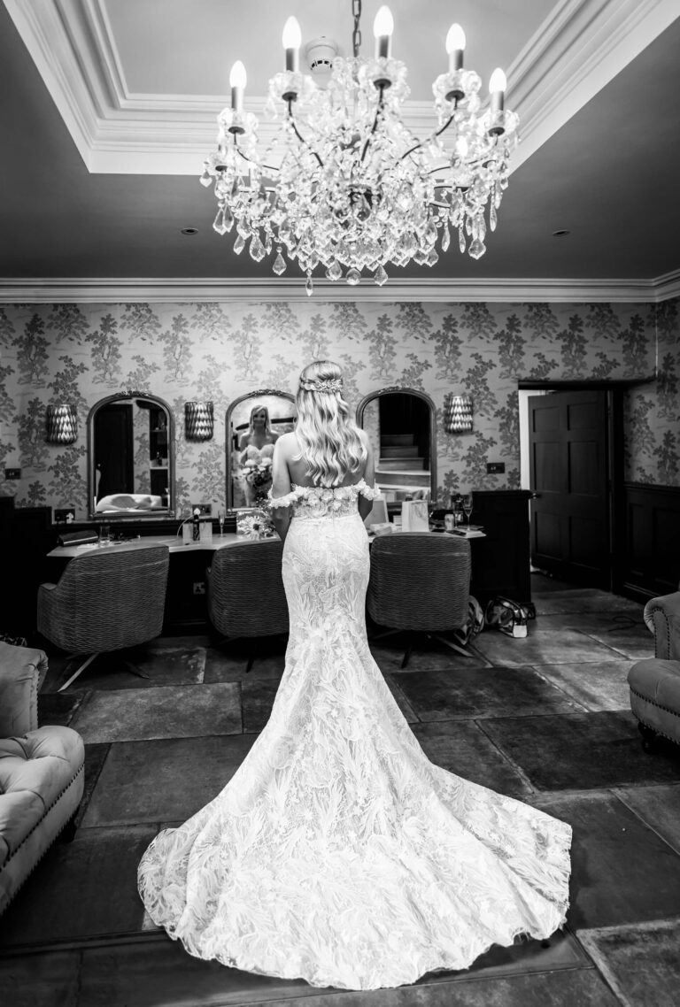 Bride in elegant gown beneath chandelier