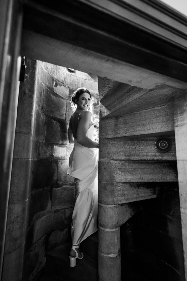 Bride ascending spiral staircase in black and white