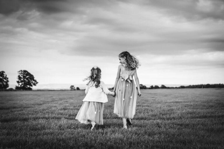 Two girls running in open field.