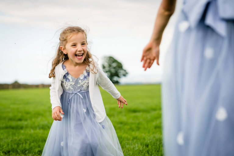 Laughing girl in blue dress outdoors
