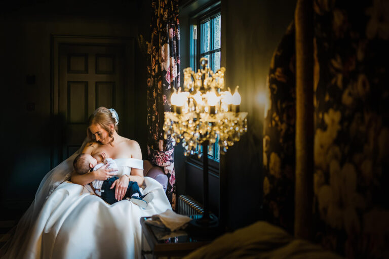Mother in wedding dress breastfeeding baby