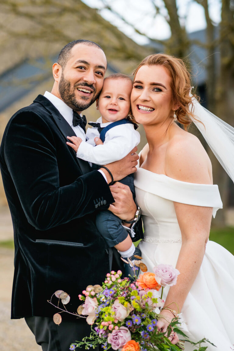 Happy couple with baby on wedding day