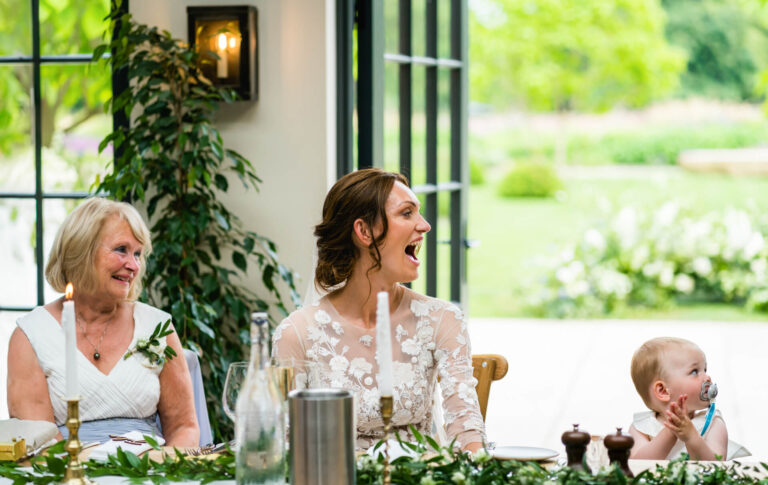 Smiling family at wedding table, enjoying celebration.