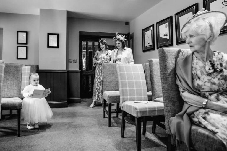 Child in dress holding card at formal event