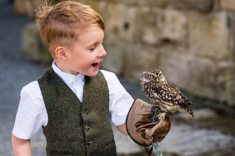 Child with owl perched on gloved hand