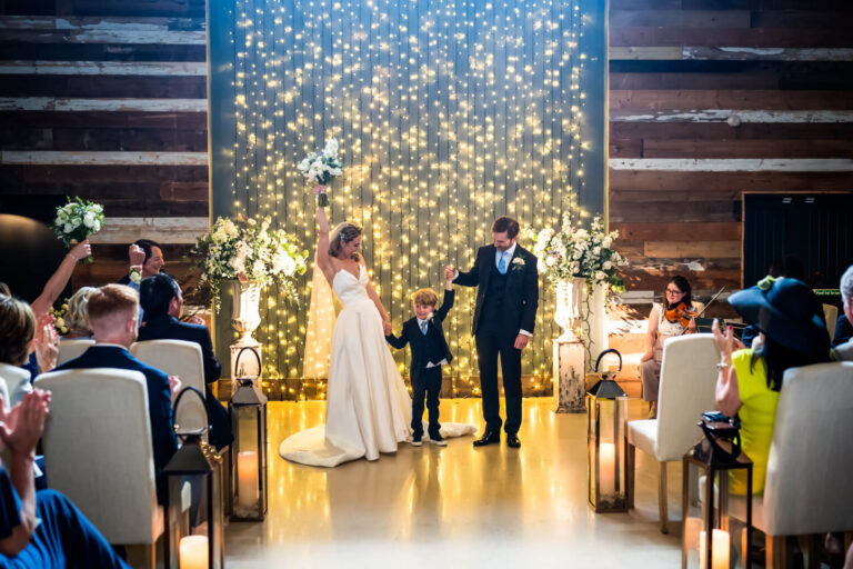 Family celebrating at wedding with fairy lights backdrop.