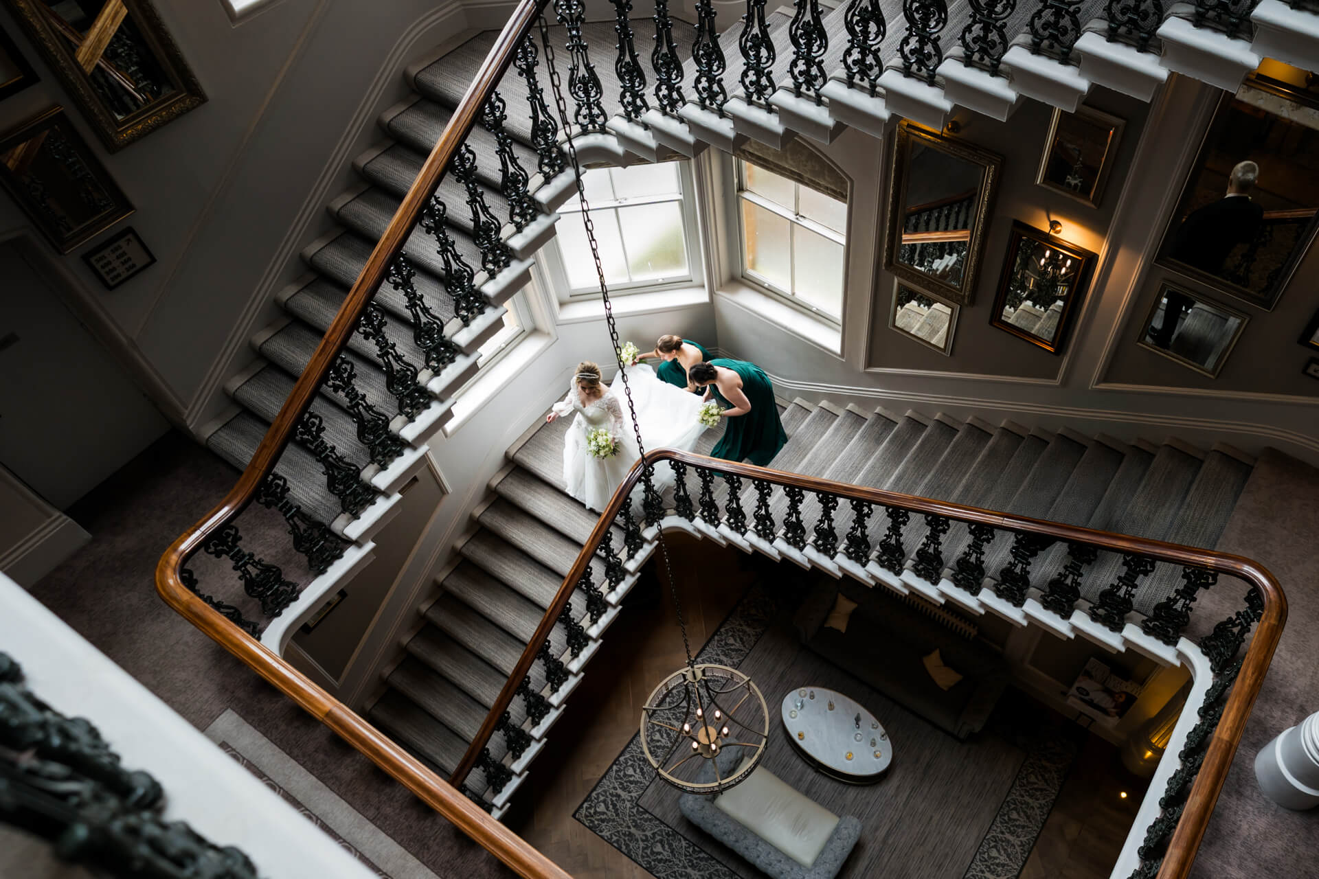Bride and bridesmaids descending grand staircase