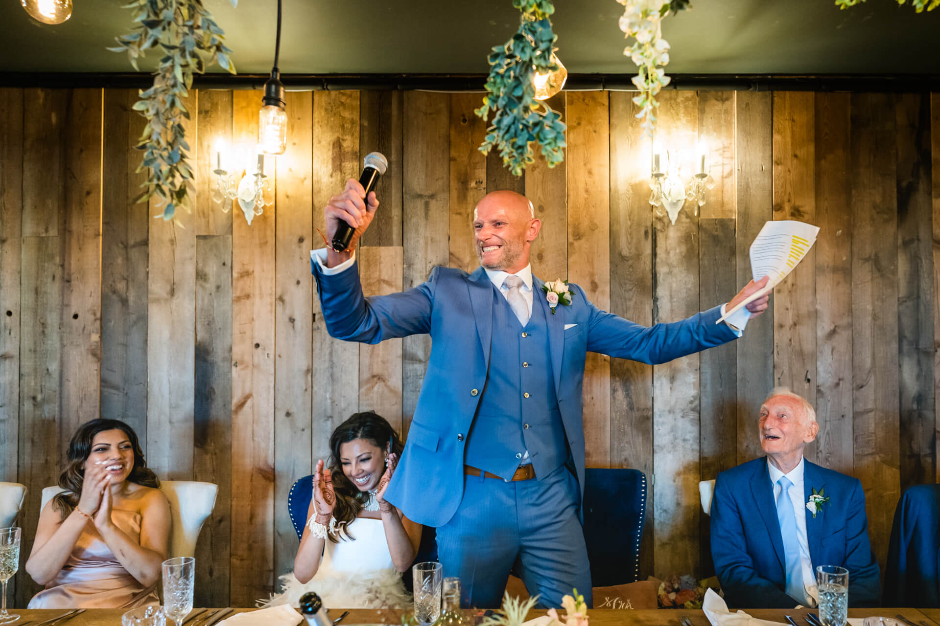 Groom giving speech at rustic wedding reception