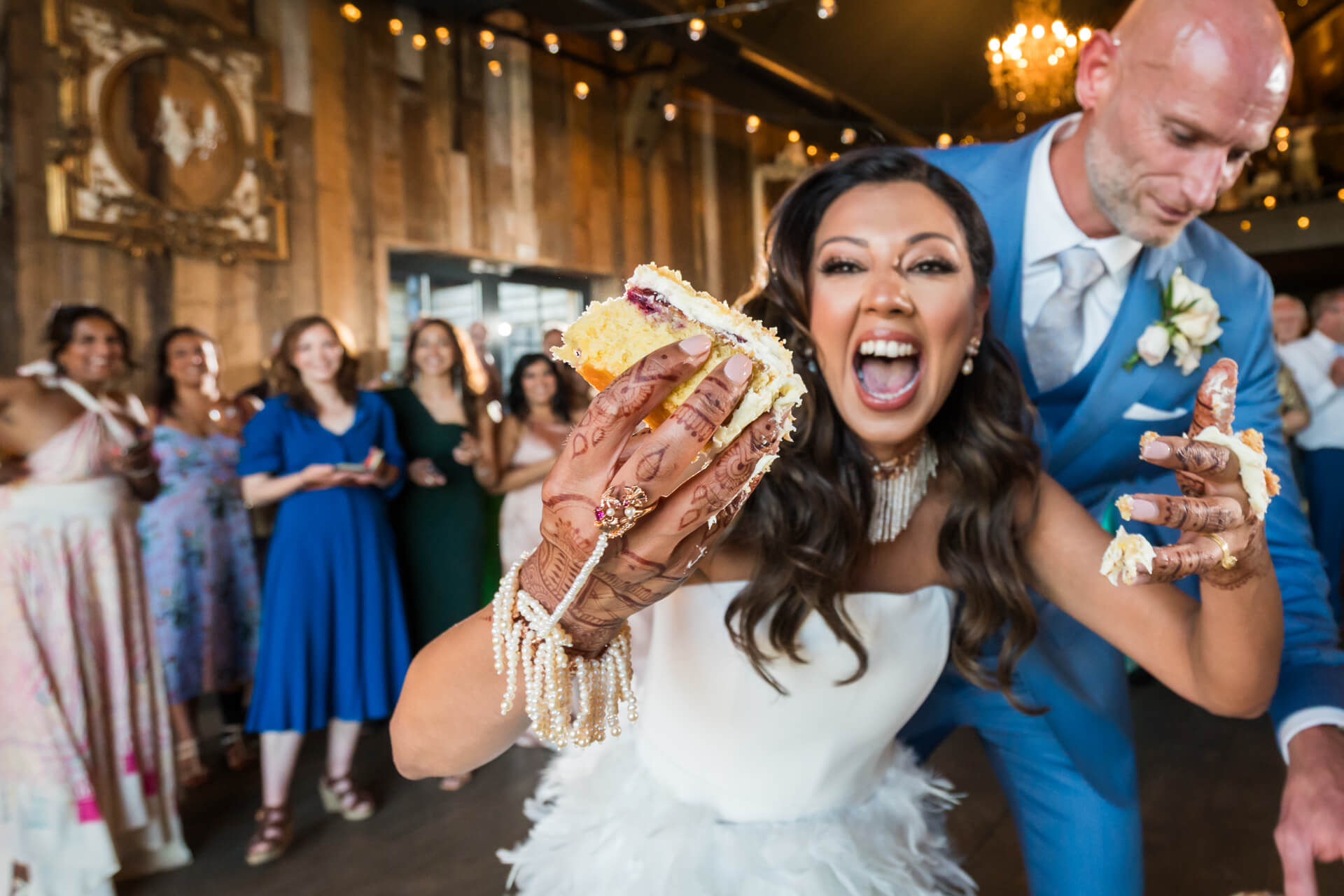 Bride playfully eating wedding cake at reception
