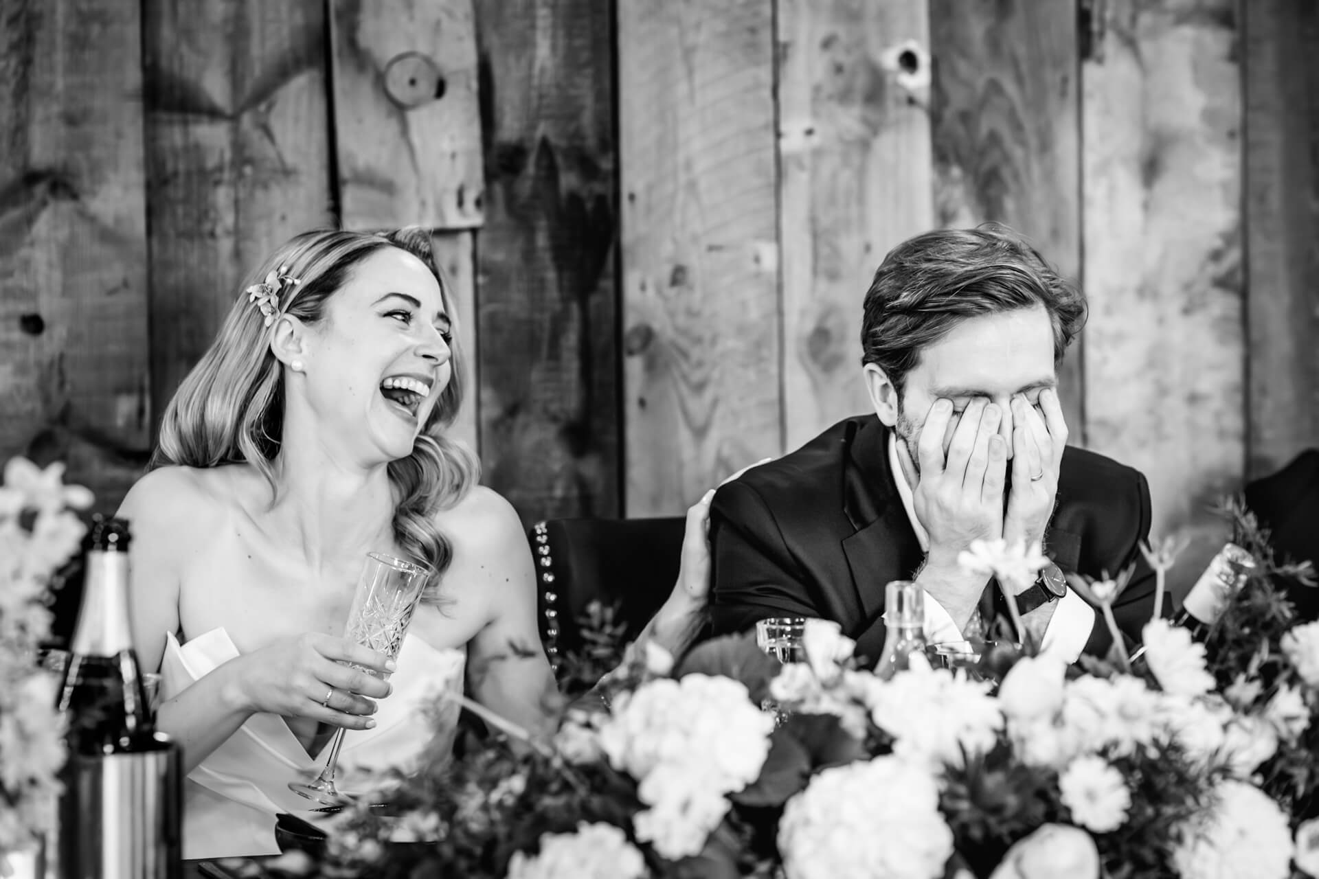 Bride laughing beside groom at wedding reception